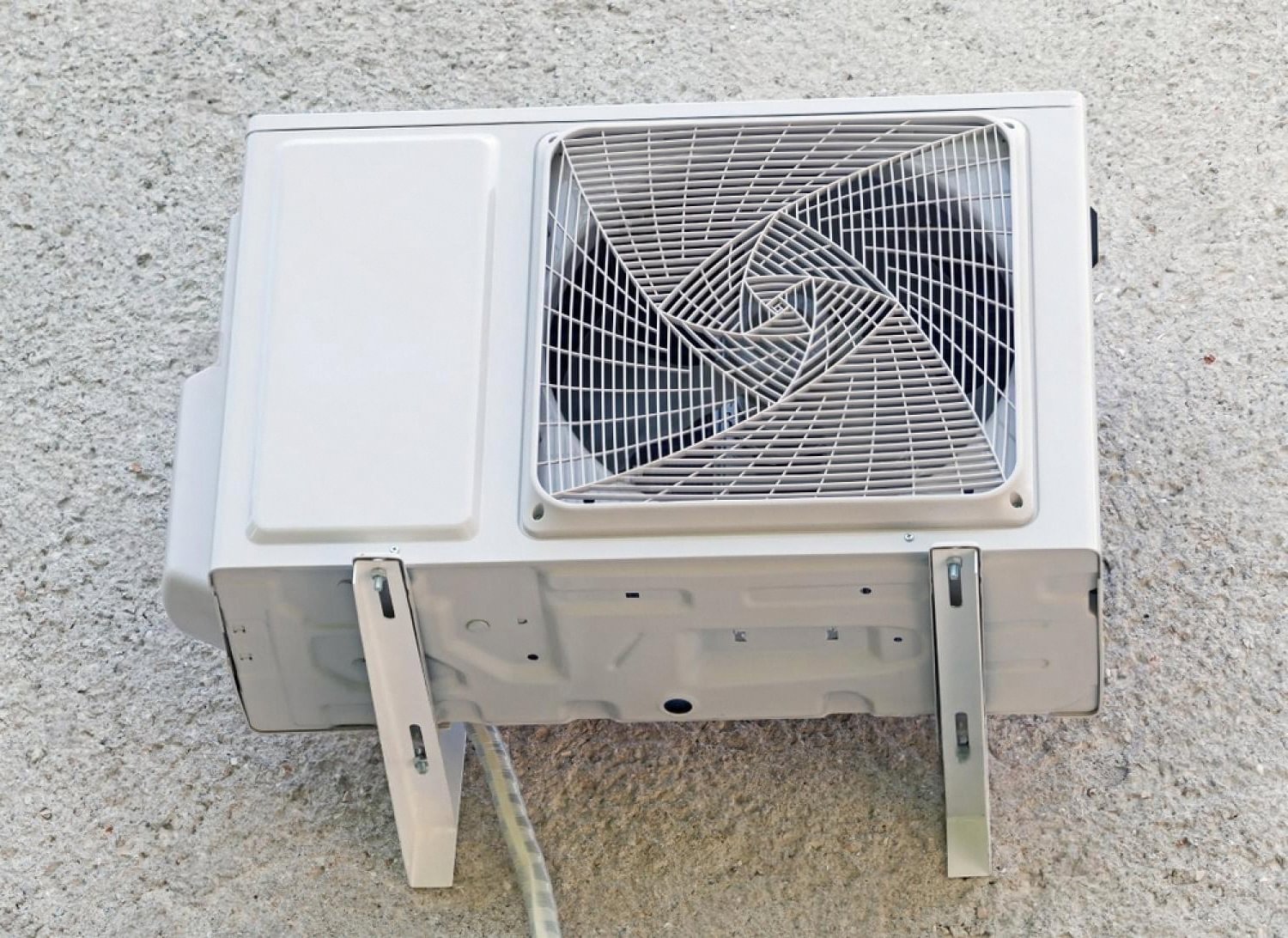 Compact evaporative air cooler unit installed against a wall