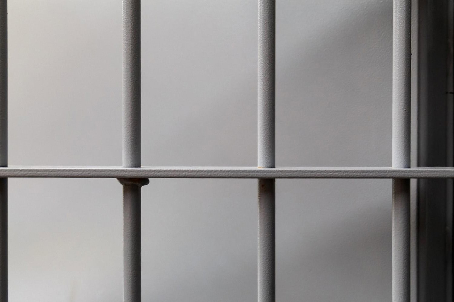 Prison bars representing criminal liability risk for dishonoured cheques under UAE law